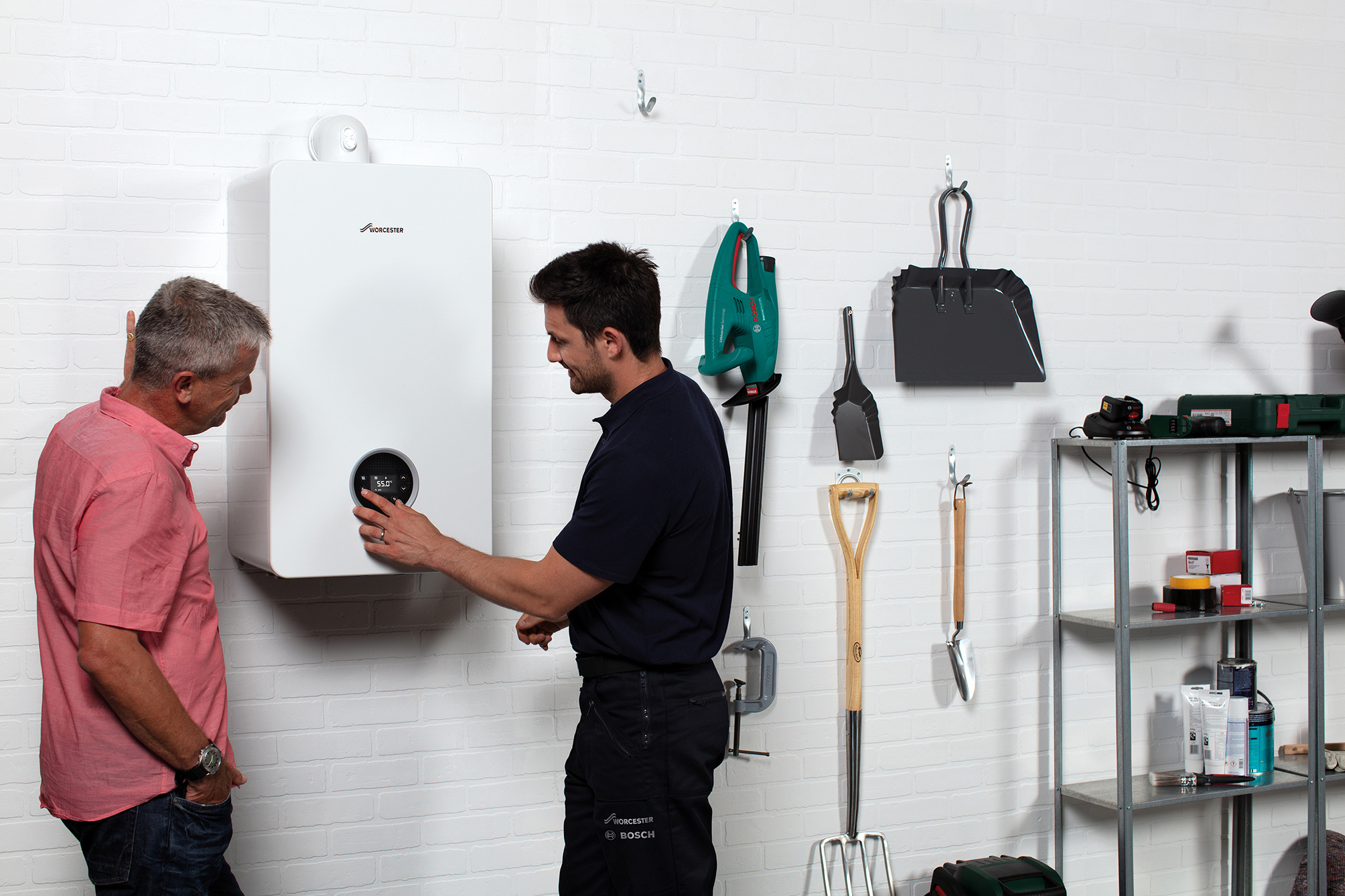 Homeowner discussing with heat engineer the cost of annual boiler service.