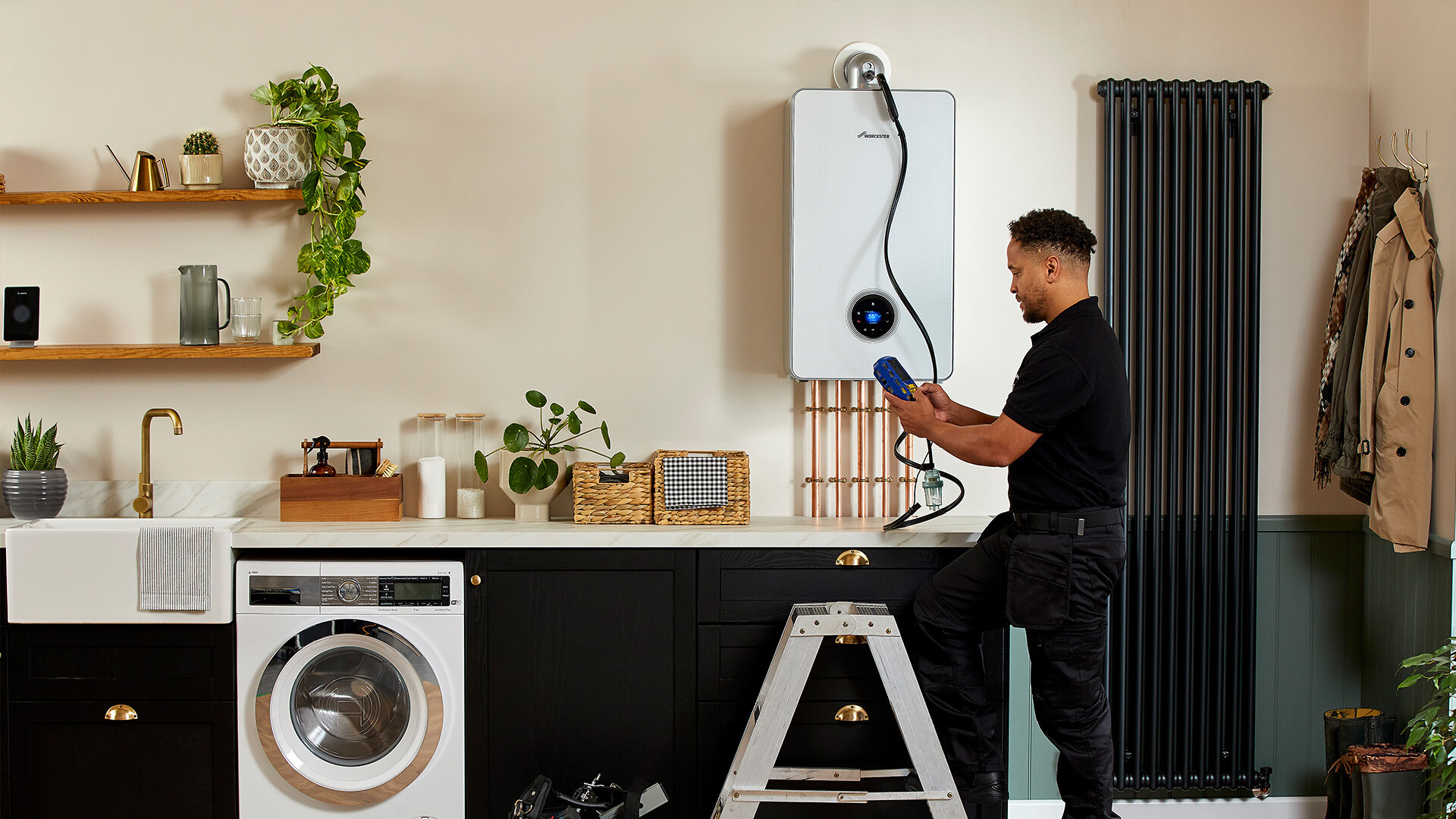 Boiler heating engineer conducting a maintenance check on a combi boiler in a kitchen.